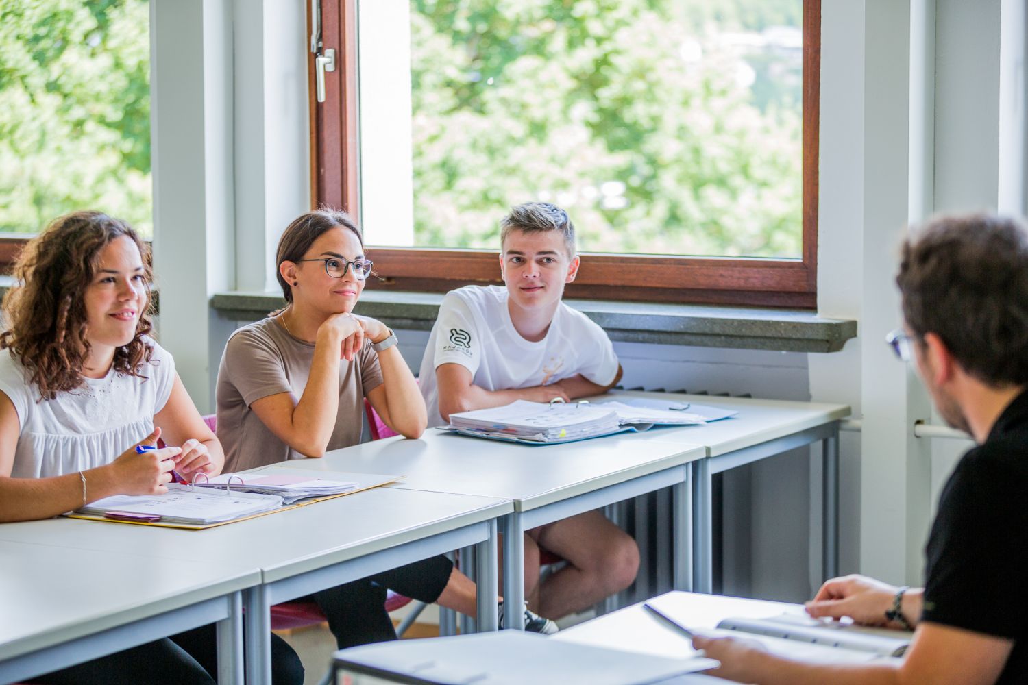 Ein Lehrer erklärt Schülern etwas im Klassenzimmer