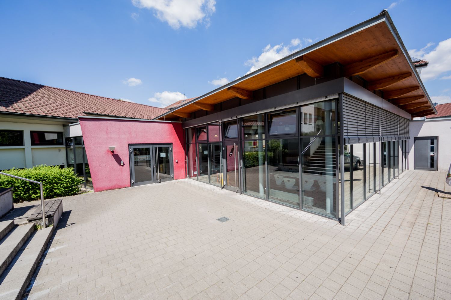 Auf dem Bild sieht man eine moderne Schule, welche aus Glaswänden besteht.
