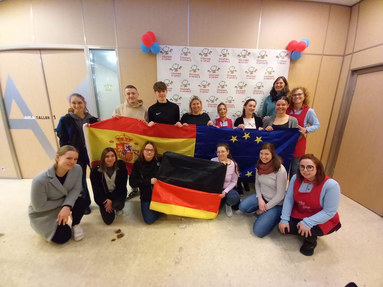 Auf dem Bild stehen mehrere Personen die drei Flaggen hochhalten.