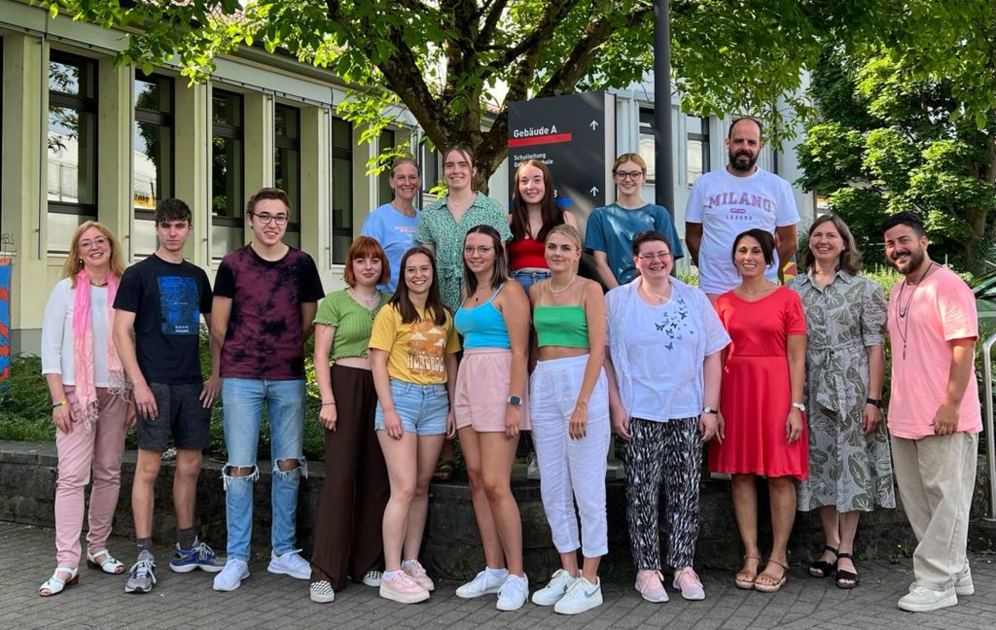 Auf dem Bild sehen wir eine Gruppe die im Pausenhof steht.