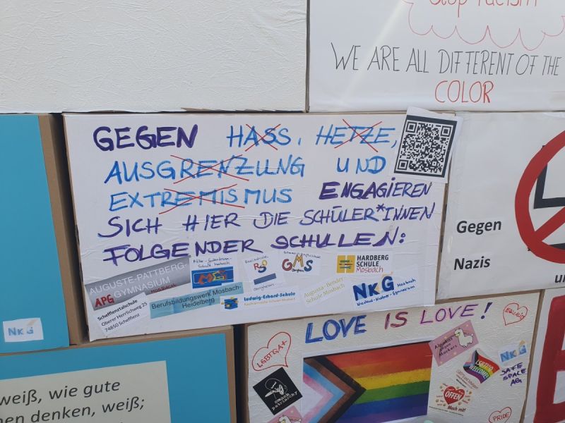 Auf dem Bild sieht man mehrere Plakate, Fokus liegt auf einem