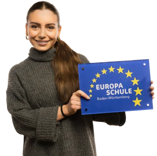 Eine Schülerin die ein Schild vor sich hält.