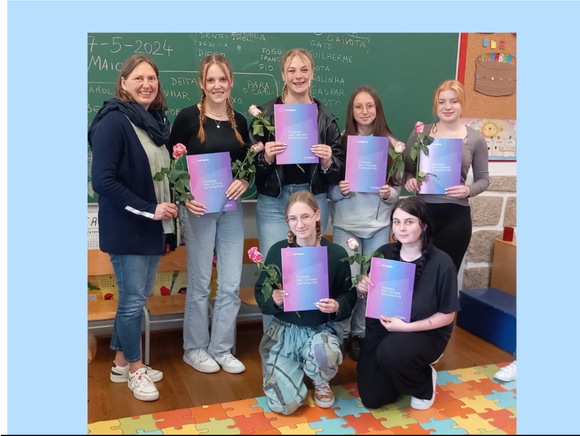 Auf dem Bild sind Schülerinnen zu sehen die ein Blatt Papier vor sich halten.