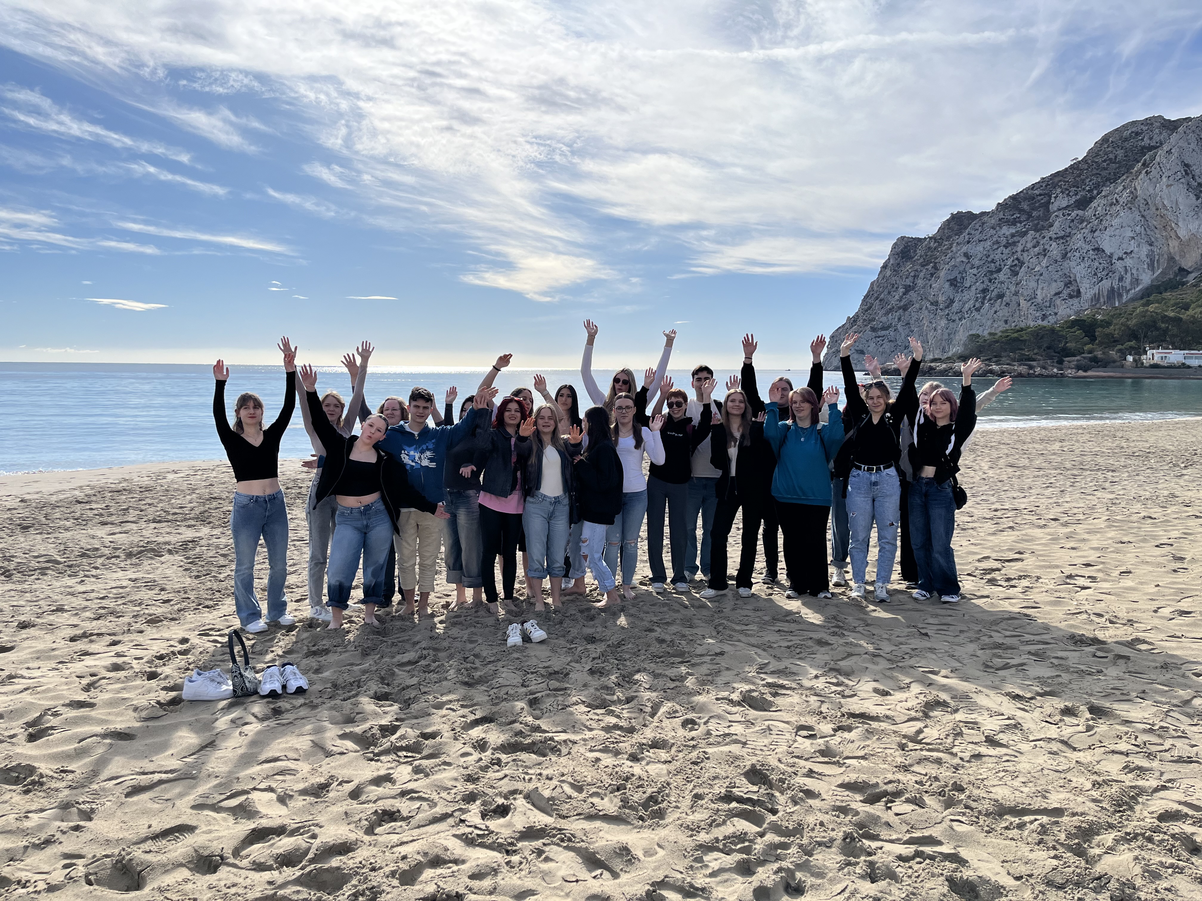 Auf dem Bild sieht man mehrere Personen die am Strand stehen.