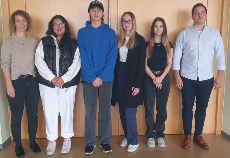 Auf dem Bild sind 6 Personen zu sehen die nebeneinander stehen
